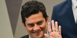 close em sérgio moro sorridente dando tchau com a mão