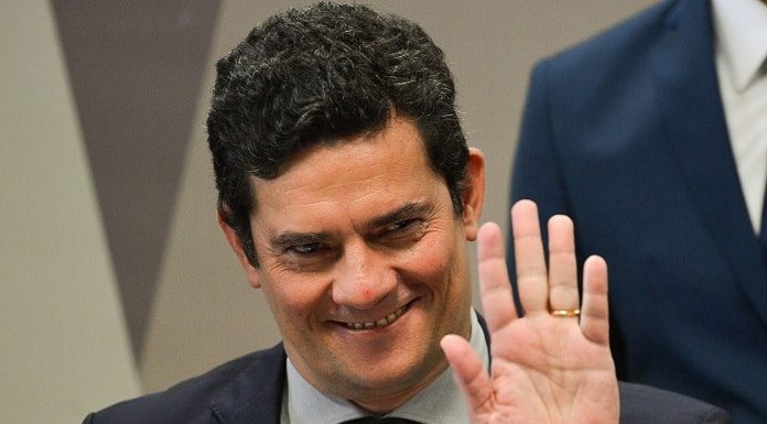 close em sérgio moro sorridente dando tchau com a mão