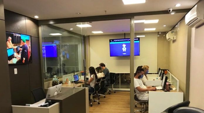 funcionários da empresa em ambiente de escritório sentados à frente de computadores