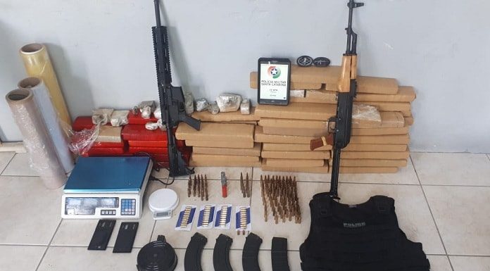 metralhadoras, tabletes de maconha e munições e outras tralhas organizados no chão