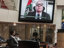 secretário em telão em transmissão no plenário da alesc