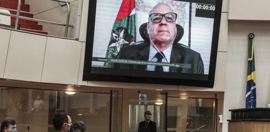 secretário em telão em transmissão no plenário da alesc