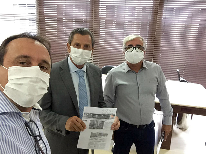 Três homens usando máscara de proteção, posando para a foto