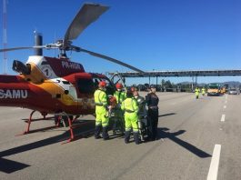 helicóptero taxiado na pista em frente ao pedágio com equipes de resgate em volta