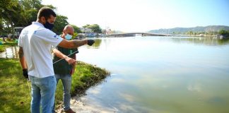 dois homens usando máscaras olhando a Lagoa da Conceição