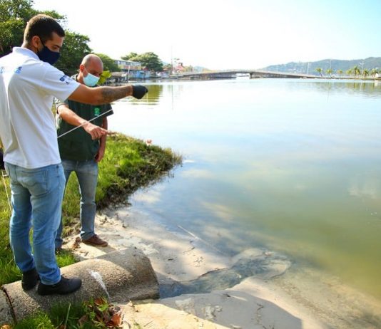 dois homens usando máscaras olhando a Lagoa da Conceição