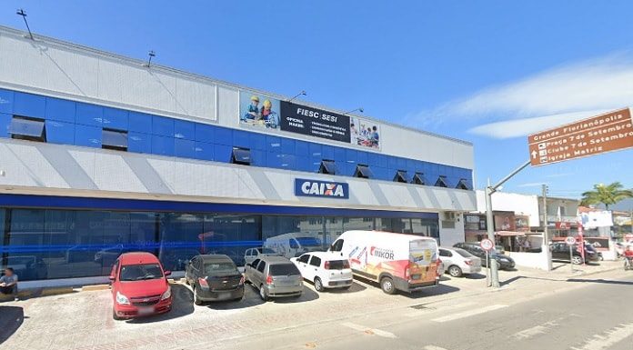 fachada da agência da caixa com carros parados na frente no centro de palhoça
