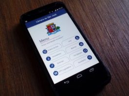 Aplicativo aproxima Câmara de São José da população durante a pandemia celular sobre mesa de madeira com o aplicativo da câmara de são josé aberto na tela