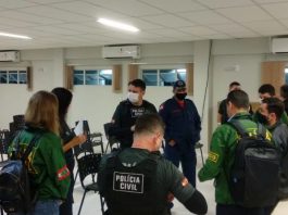 policiais homens e mulheres reunidos em pé em auditório usando uniformes da pc antes do início da operação