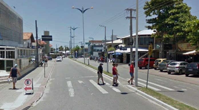 pessoas andando na faixa de pedestre em avenida nos ingleses em dia de céu limpo, comércios em volta, carros estacionados