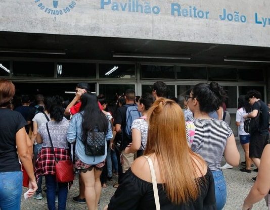 Inscrições para o Enem 2022 começam nesta terça-feira diversos jovens vistos de costas e em pé à espera de entrar em local para fazer prova do enem