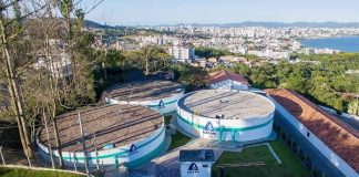 reservatórios circulares da casan no topo do morro do centro histórico de são josé com a cidade ao fundo