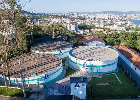 reservatórios circulares da casan no topo do morro do centro histórico de são josé com a cidade ao fundo