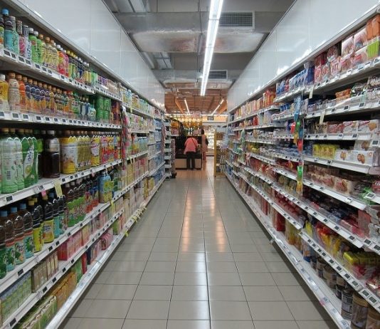 Compras online, farmácias, delivery, supermercados: negócios em alta em SC corredor de um supermercado cheio de produtos nas prateleiras e caixa ao fundo