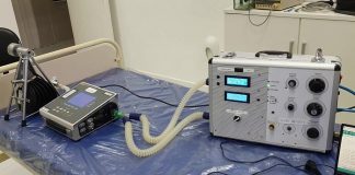 protótipo de respirador sobre mesa de hospital com outros equipamentos em volta