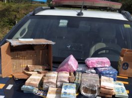 dinheiro empilhado sobre capô de viatura da prf