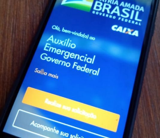 Ministério Público e Controladoria-Geral investigam pagamento de auxílio emergencial Auxílio Emergencial: Celular em cima da mesa com o aplicativo CAIXA Tem aberto.