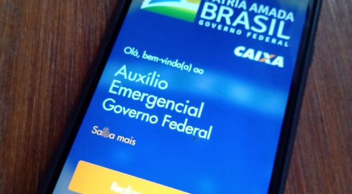 Auxílio Emergencial: Celular em cima da mesa com o aplicativo CAIXA Tem aberto.