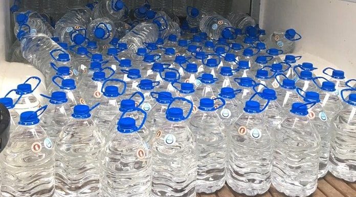 garrafas de 5 litros cheias de álcool arrumadas lado a lado