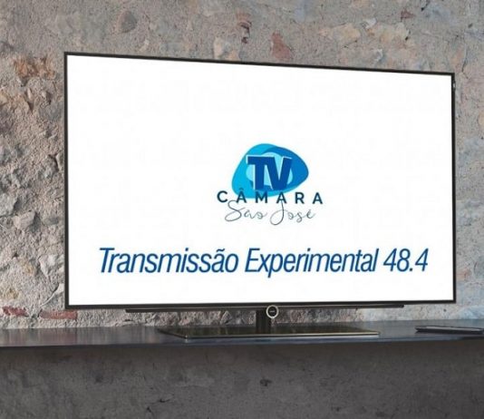 televisor com uma projeção do logo da tv câmara e escrito "transmissão experimental 18.4"