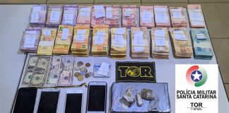 dinheiro, drogas e celulares em cima de uma mesa na delegacia de polícia