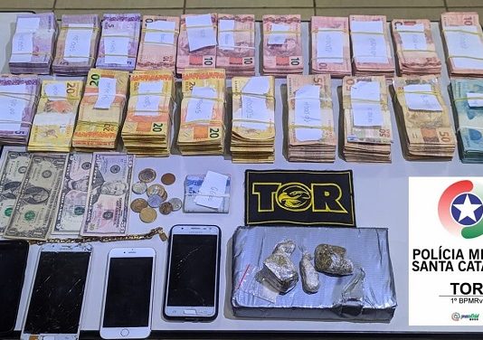 dinheiro, drogas e celulares em cima de uma mesa na delegacia de polícia