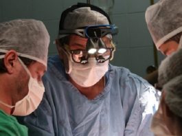três médicos usando máscaras em sala de cirurgia