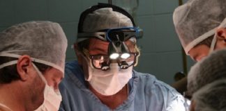 três médicos usando máscaras em sala de cirurgia