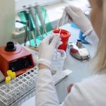 mulher usando luvas fazendo teste de laboratório