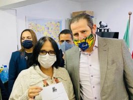 Casa da Mulher: Vereador Antônio Lemos pede apoio de Ministra para trazer projeto para São José homem usando máscara entrega uma carta para uma mulher também usando máscara