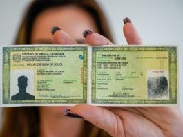 mulher mostra para a foto modelo de carteira de identidade com nome social