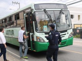 dois ficais e um guarda do município de palhoça em frente a um ônibus da jotur