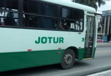 ônibus da empresa jotur visto de lado com logo em evidência no centro da foto