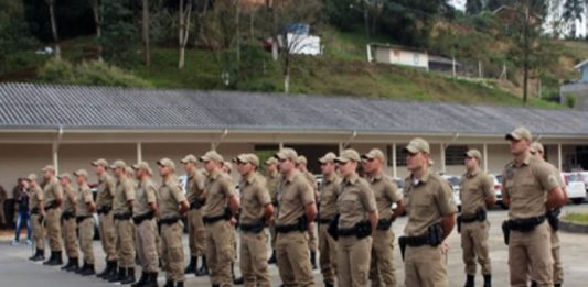 tropa de cerca de 30 policiais militares em posição de sentido