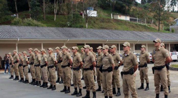 tropa de cerca de 30 policiais militares em posição de sentido