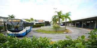 ônibus fazendo o retorno dentro do terminal do centro de florianópolis com plantas ao redor da pitas