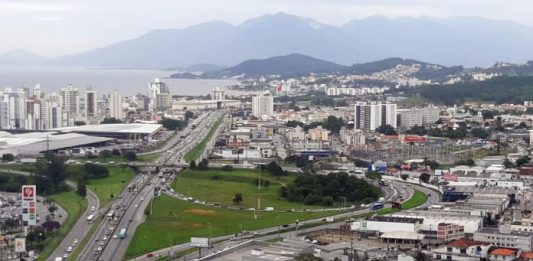 foto aérea do entroncamento das br 101 e 282 em são josé com cidade em volta e montanha do cambirela ao fundo