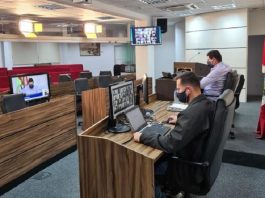 dois homens usando máscara em frente a computadores na mesa diretora do plenário da câmara de são josé