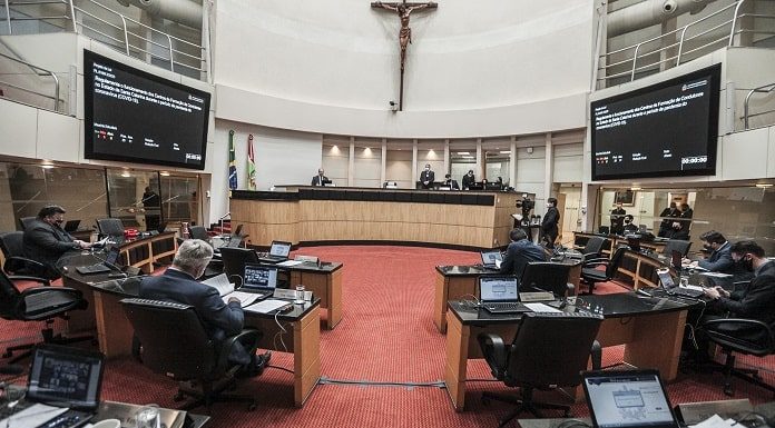 homens sentados na tribuna da Assembléia Legislativa