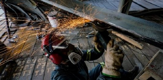 Santa Catarina tem melhor resultado na geração de emprego entre estados do Sul e Sudeste homem usando capacete e máscara soldando uma estrutura na ponte
