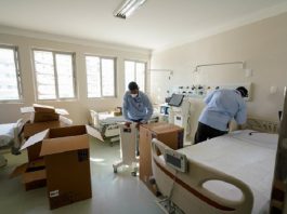 Governo pede autorização à Alesc para crédito de R$ 75 milhões contra coronavírus dois homens desencaixotam equipamentos dentro de quarto de enfermaria com duas camas