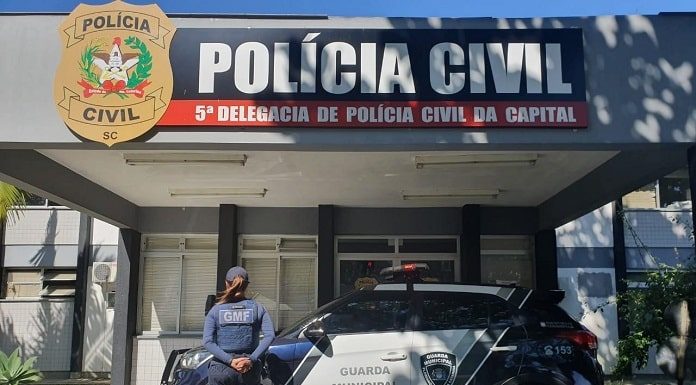 policial feminina de costas perto de uma viatura