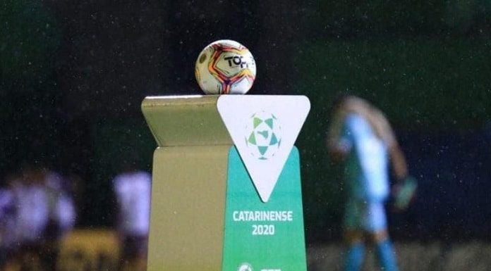 bola de futebol sobre uma bancada personalizada com logos do futebol catarinense 2020