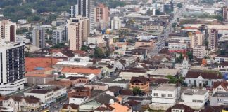 cidade de joinville com centenas de casas e prédios em área plana vista do alto