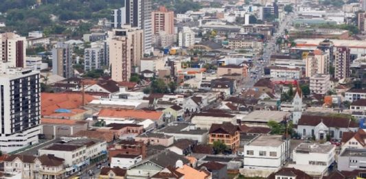 Justiça nega pedido de lockdown no município de Joinville por mais 14 dias cidade de joinville com centenas de casas e prédios em área plana vista do alto