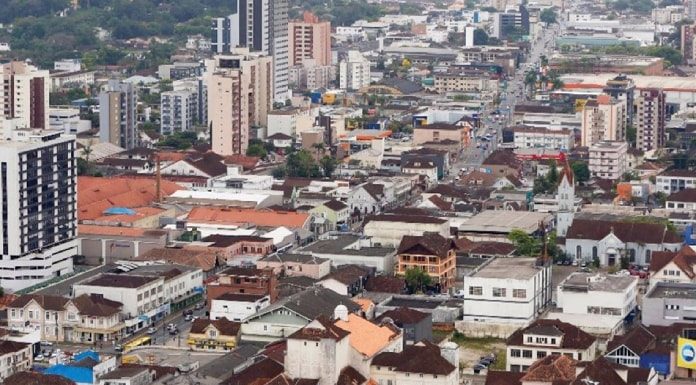 cidade de joinville com centenas de casas e prédios em área plana vista do alto