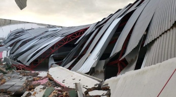 ginásio de escola destruído com escombros de alvenaria e o galpão desabado