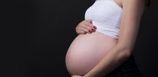MPT-SC recomenda afastamento do trabalho presencial para gestantes durante a pandemia mulher grávida vista de lado com barriga de fora e com as mãos em cima e embaixo