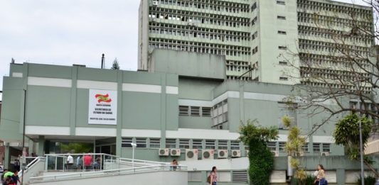 Emergência do Hospital Celso Ramos é reaberta fachada do prédio do hospital vista do outro lado da rua; mulher passa na calçada