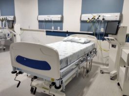 cama de hospital arrumada com equipamentos ao lado